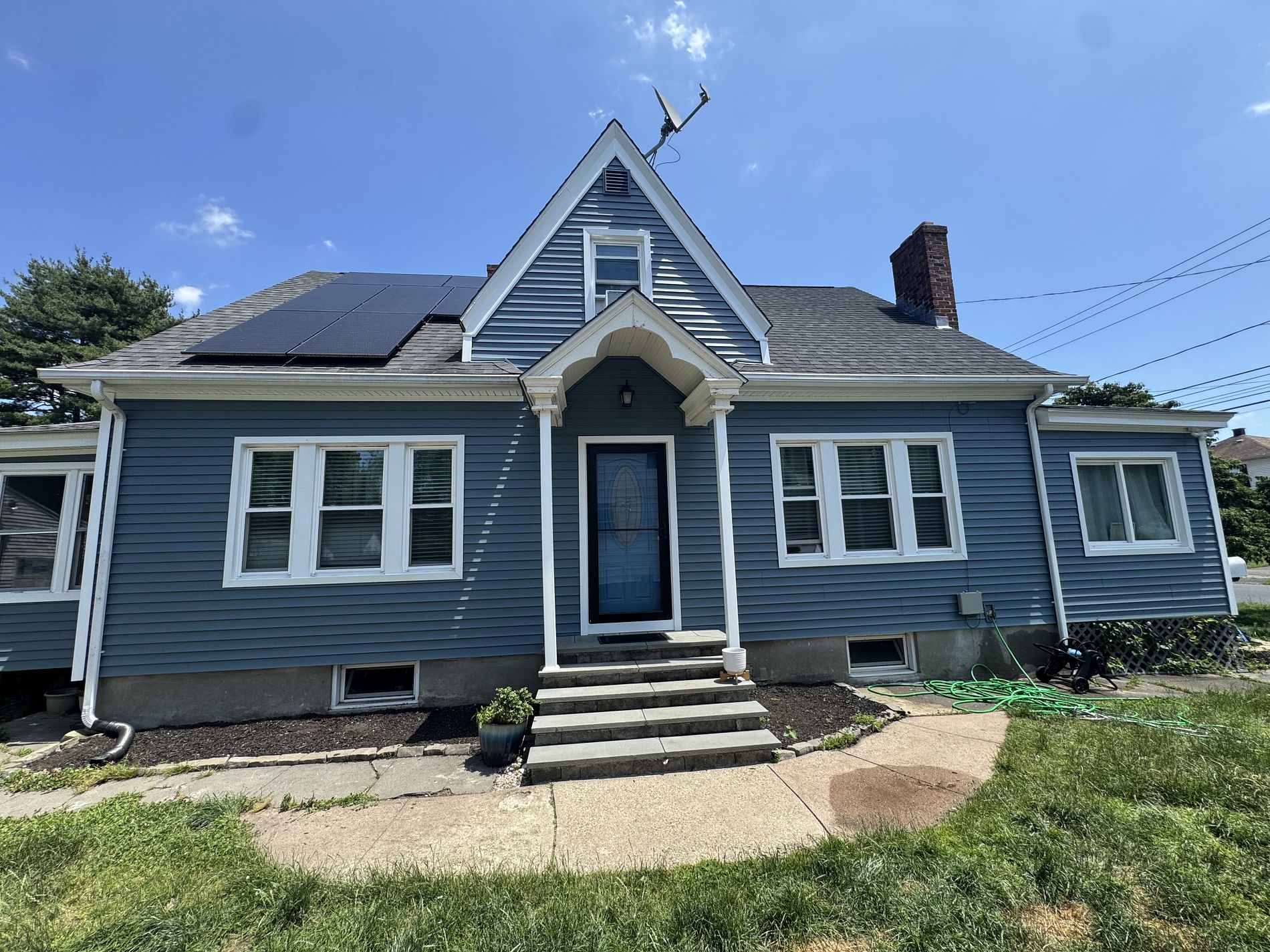 McKee Street East Hartford CT home with new slate blue vinyl siding and white trim after renovation