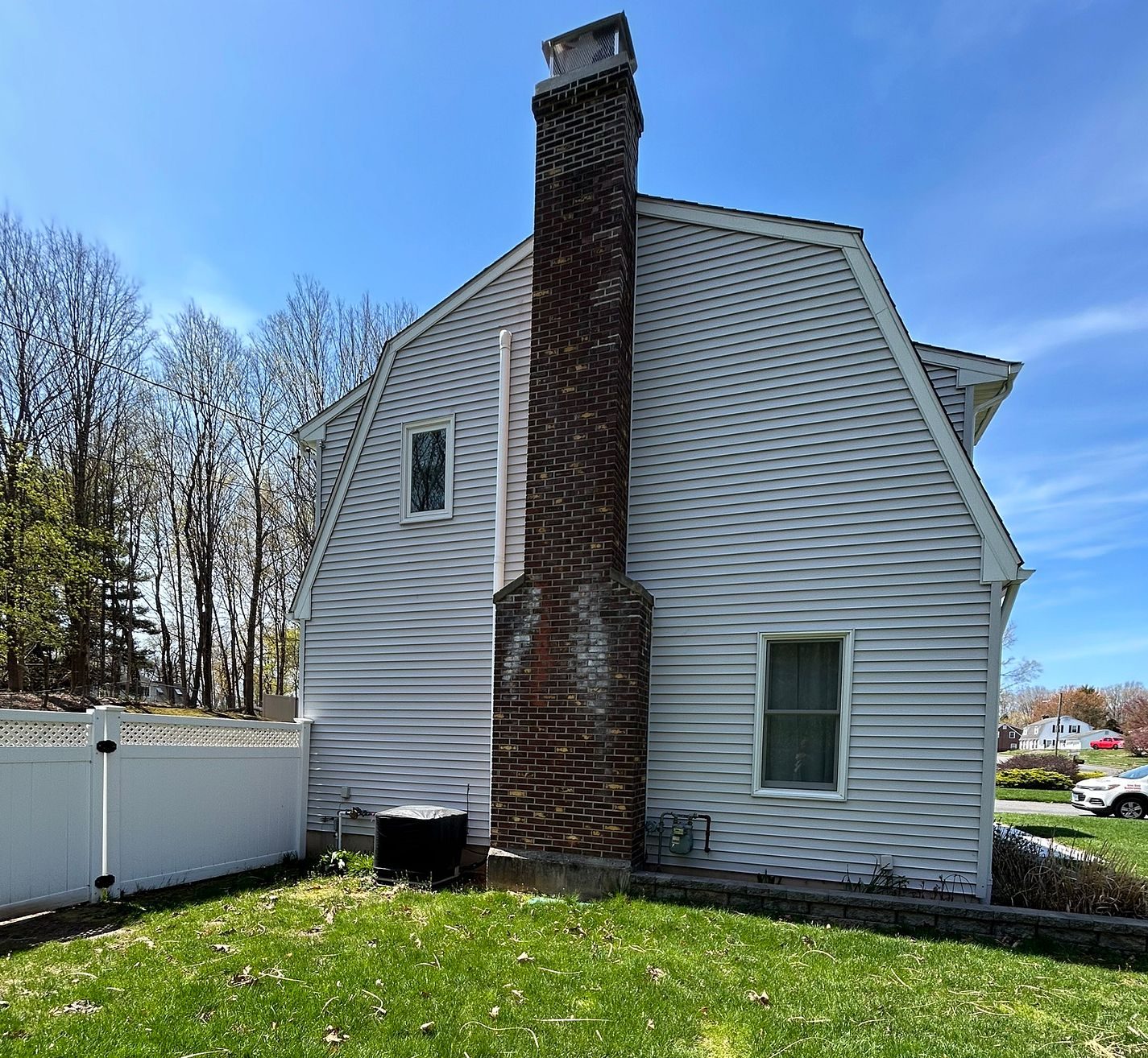 Before photo of a gambrel-style home on Anton Lane in Berlin, CT with original aged white vinyl siding before Nu-Face replacement