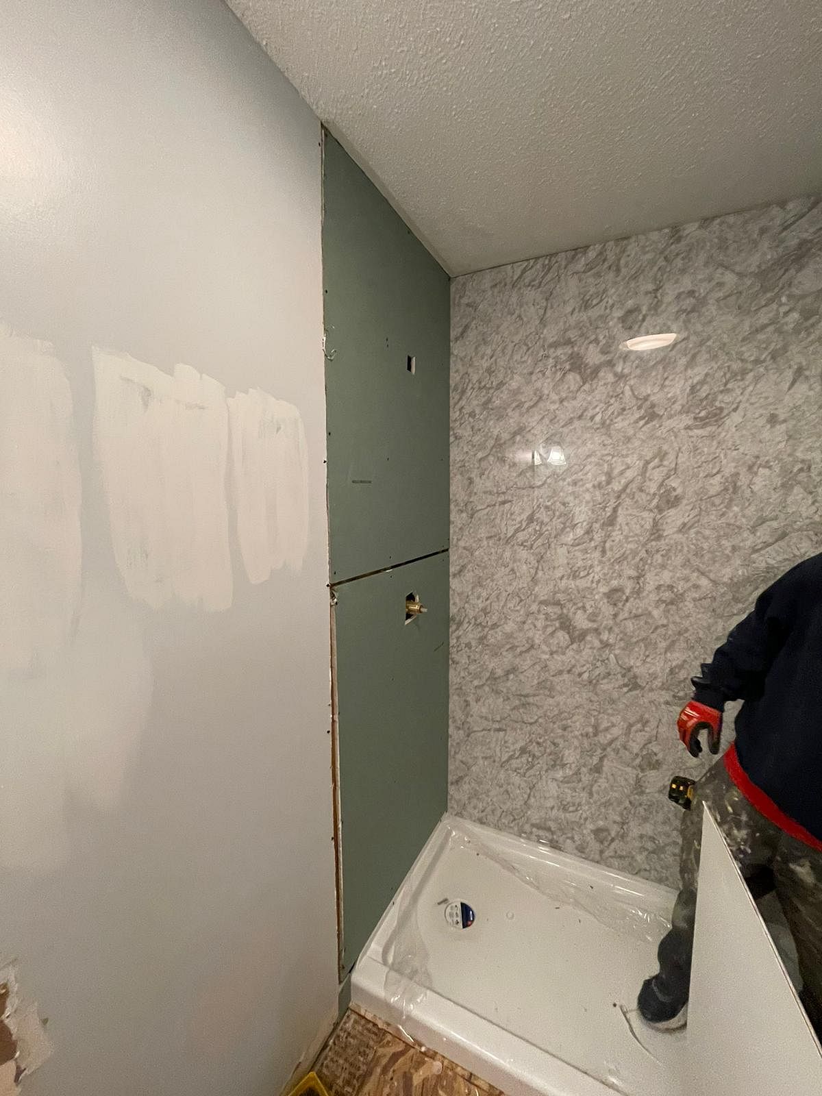 Clock Shop Drive Berlin CT bathroom remodel in progress showing Nu-Face installer fitting gray marble Luxury Bath acrylic panels with shower pan installed