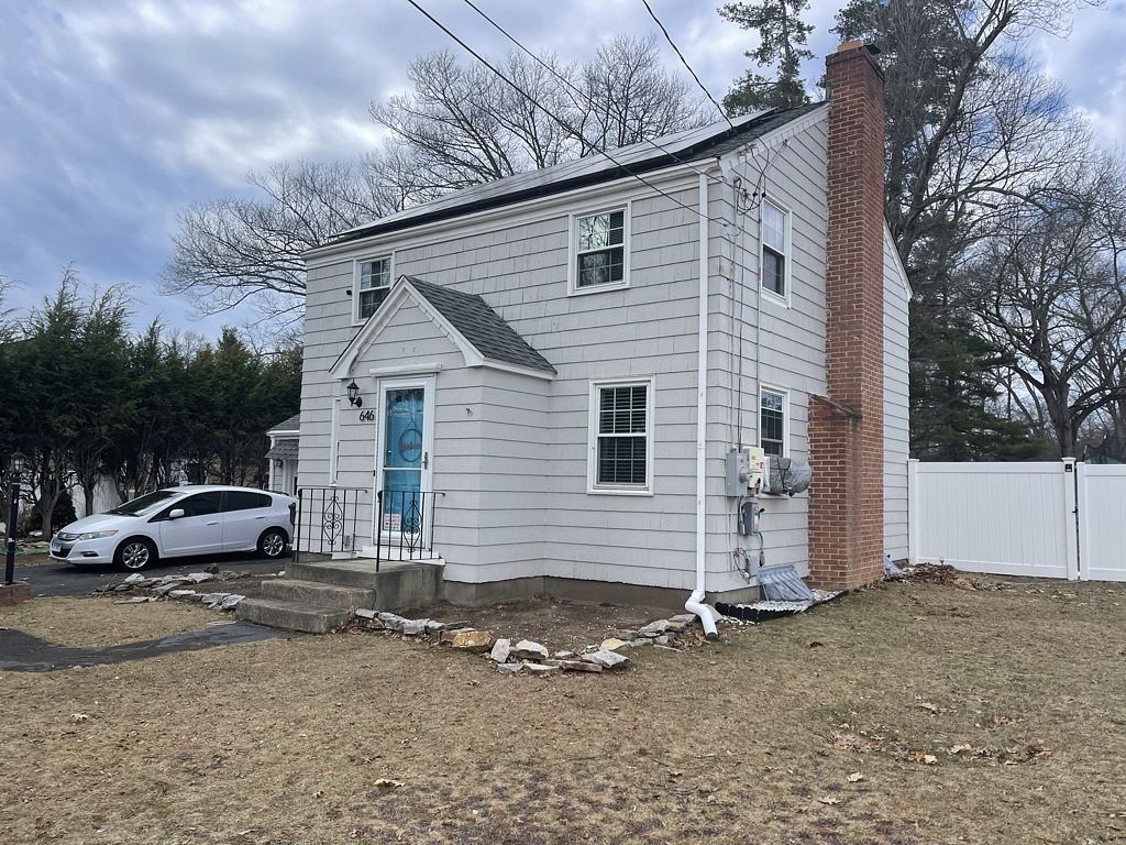 Before photo of gray shingle siding on side of colonial home