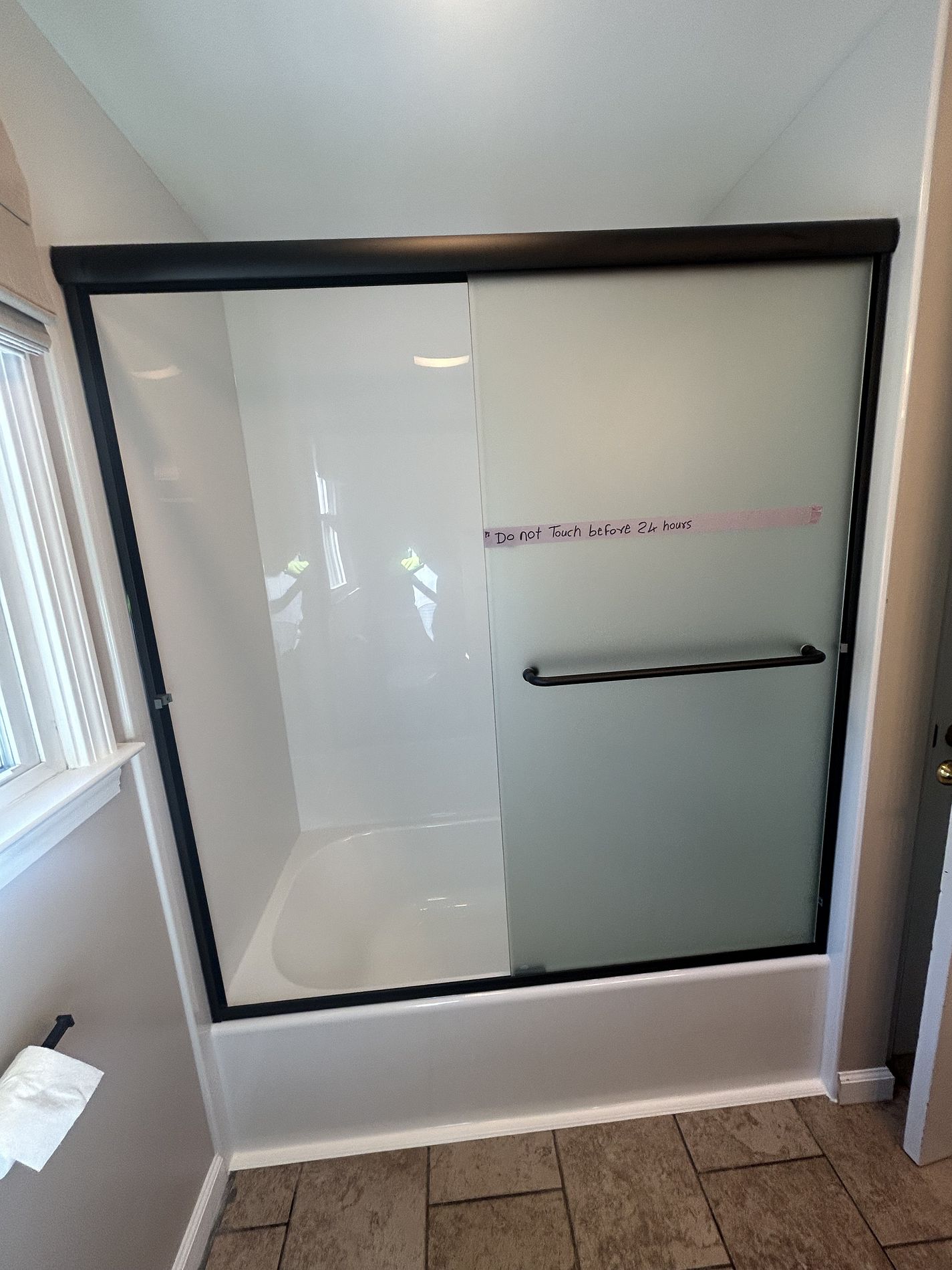 Updated Valley Drive Berlin CT bathroom showing new Luxury Bath acrylic wall panels matte black framed sliding door and do not touch installation note visible on fresh surround