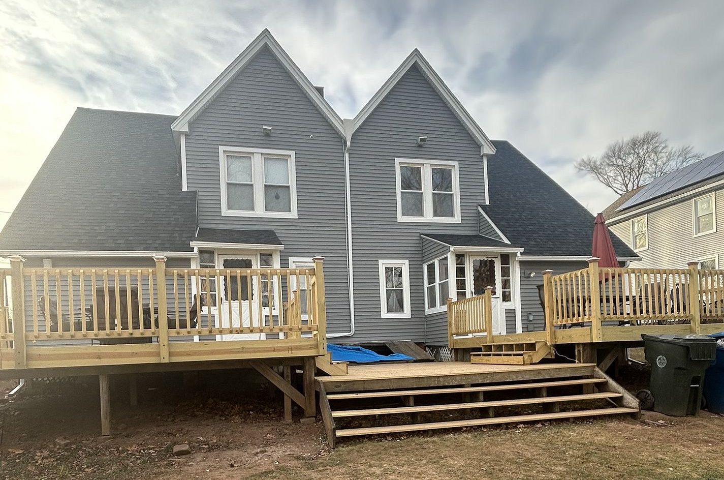 Completed siding replacement on a Wilcox Avenue home in Berlin, CT featuring charcoal gray vinyl siding with white trim
