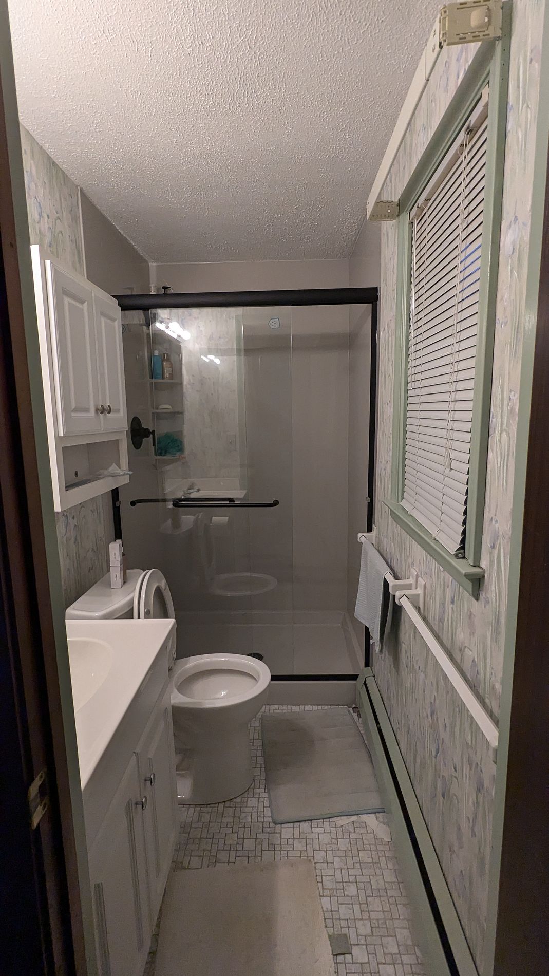 Completed tub-to-shower conversion with glass doors and grab bar on Whitney Circle in Windsor, CT